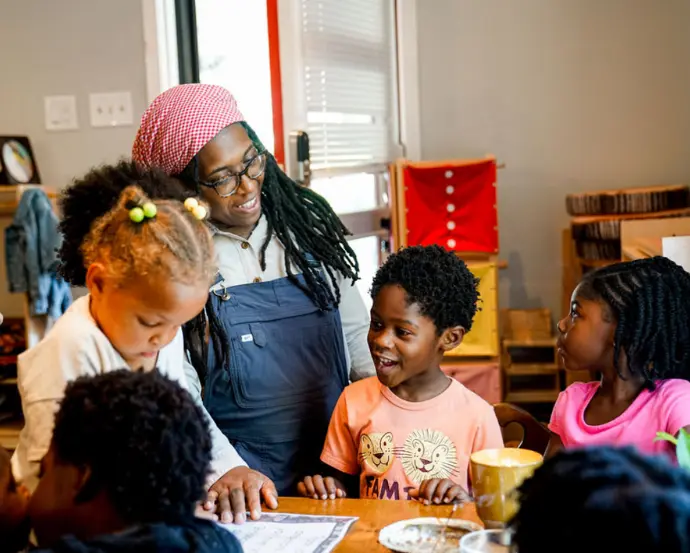 A teacher with five students in a classroom.