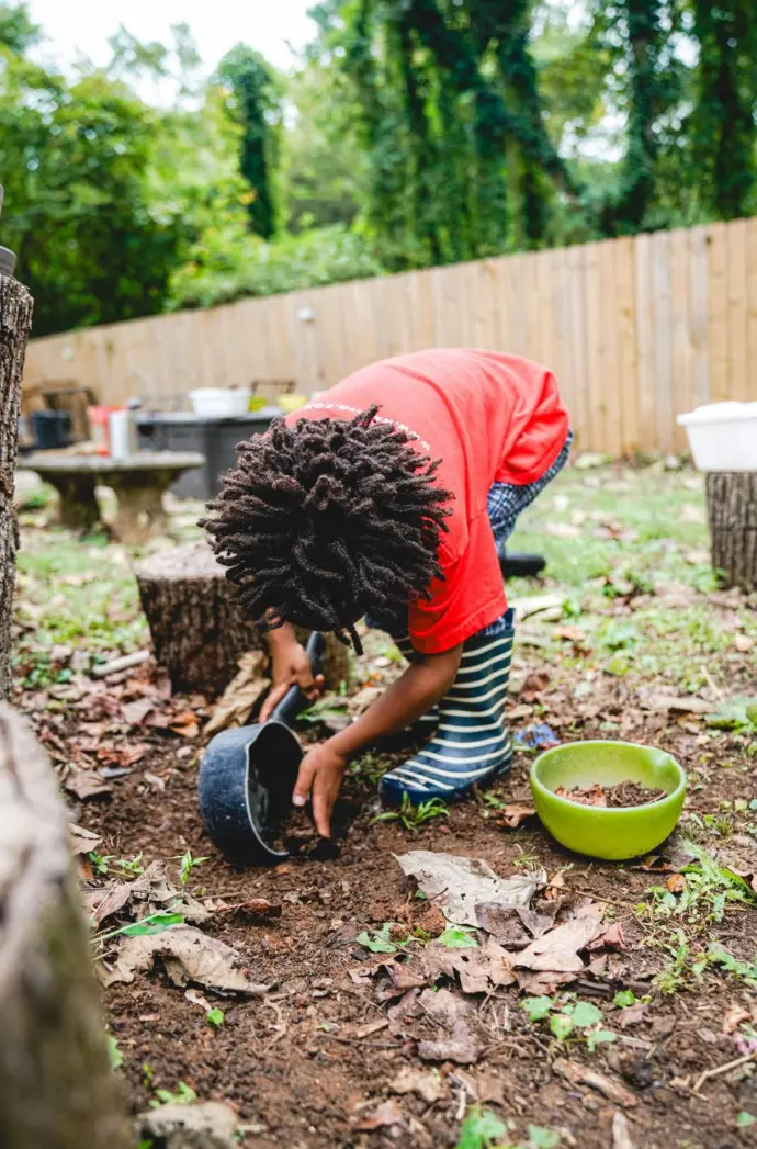 A young boy gathering soil.