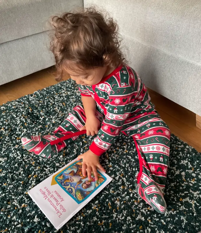 Toddler reaches for TinkerTell book.
